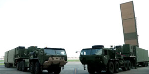 A ground-based missile launcher silhouetted against a rising sun, with a Japanese flag subtly integrated into the background, symbolizing the military deployment and strategic partnership between the two nations.