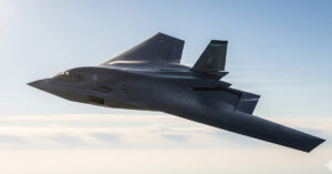 The U.S. Air Force's B-21 Raider stealth bomber, a sleek and futuristic aircraft, shown in mid-flight against a clear sky, highlighting its advanced design and stealth capabilities.