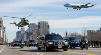 A dramatic photo of the US presidential motorcade with The Beast limousine, Marine One helicopter, and Air Force One in the sky.